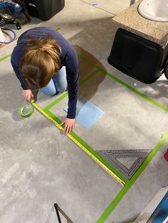 a woman is measuring the floor with a tape