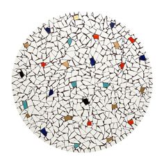 a white plate topped with lots of small pieces of mosaic glass on top of it