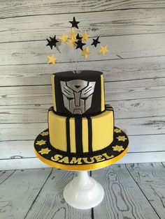 a yellow and black cake with stars around it