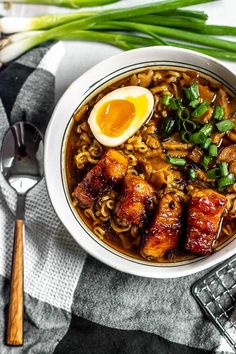 an overhead view of a bowl of ramen with noodles, eggs and green onions