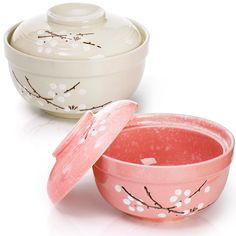 two bowls with lids are sitting next to each other on a white surface, one has an open lid and the other has flowers painted on it