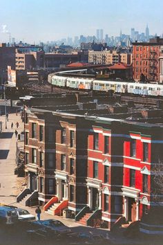 a train traveling through a city next to tall buildings with lots of windows on each side