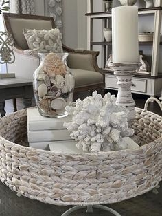 a wicker basket on a table with books and candles