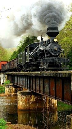 an old steam engine train traveling over a bridge