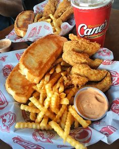 fried chicken, french fries and coleslaw on a paper plate with a cup of sauce