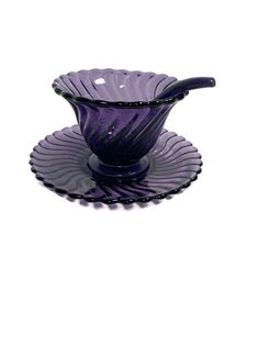 a purple glass bowl sitting on top of a saucer