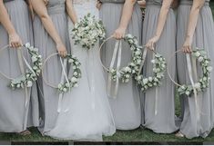 the bride and her bridesmaids are holding their bouquets with ribbons around them