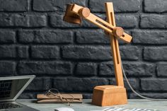 a wooden desk lamp sitting on top of a table next to a laptop and mouse