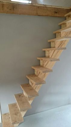 a wooden stair case in a white room