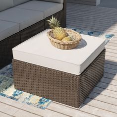 a pineapple sitting on top of a wicker box next to a couch and coffee table