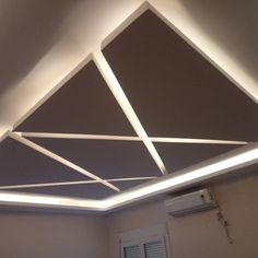 a room with a ceiling that has some lights on top of it and an air conditioner in the corner