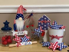 an assortment of patriotic decorations on a table with jars and utensils in the shape of gnomes