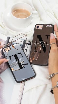 a woman holding an iphone case next to a cup of coffee and eyeglasses