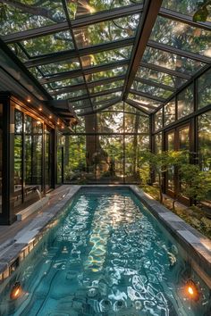 an indoor swimming pool in the middle of a house with glass walls and ceilinging