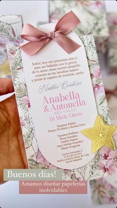 a person holding up a wedding card with a star on the front and pink flowers on the back