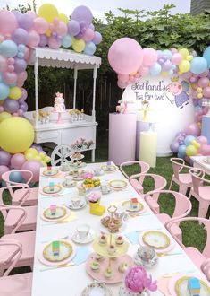 a table set up for a tea party with balloons