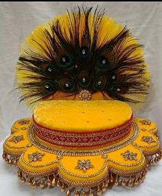 an elaborate yellow hat with peacock feathers on it's head and two other hats