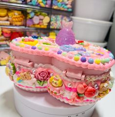 there is a pink cake with buttons on it