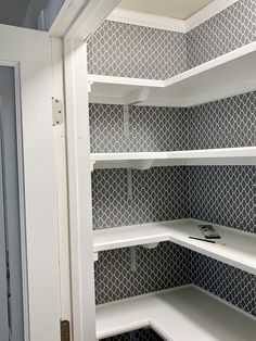 an empty white pantry with shelves in it