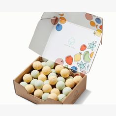 an open box filled with assorted macaroni and cheese balls on a white background