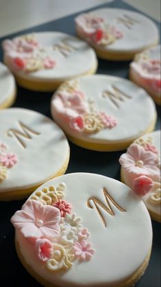 decorated cookies with the letter m and flowers on them are arranged in order to be personalized