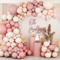 a pink and white backdrop with balloons, candles, vases and other items in front of it