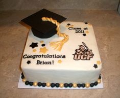 a graduation cake with congratulations written on it and a mortar cap sitting atop the cake