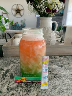 a glass jar filled with liquid next to a tube of toothpaste on a counter