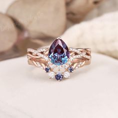 a blue and white diamond ring sitting on top of a rock