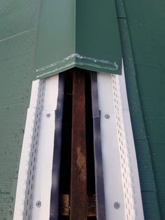 the side of a green building with metal beams