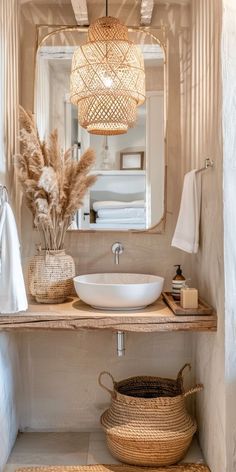 a white sink sitting under a bathroom mirror next to a basket filled with dry grass