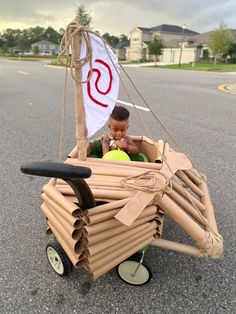 a boy in a cart made out of cardboard