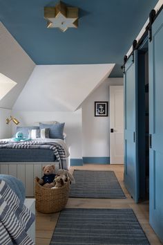 a bedroom with blue walls and carpeted flooring in the room, along with a bed