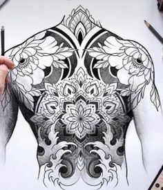 a man's back is drawn with black and white ink while he holds his pencils