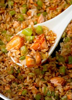 a spoon full of rice and vegetables being stirred