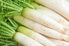 some white radishes are laying on top of green grass