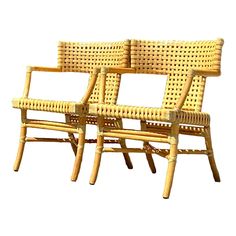 two chairs made out of wicker sitting next to each other on a white background