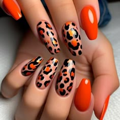 The nails are painted in a bright orange. Each nail features black and brown leopard spots, creating a wild and adventurous look. The spots are irregularly shaped and scattered across the nails. The glossy finish adds a sleek shine to the design. Orange And Black Leopard Print Nails, Orange Cheetah Print Nails, Orange Leopard Nails, Black And Orange Nail Designs, Orange Leopard Print, Top Nails, Gel Nails Diy