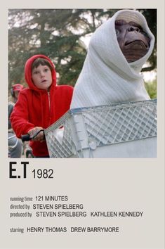 a child in a red hoodie riding a bike next to an advertisement for a movie