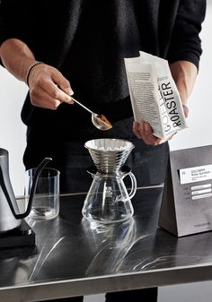 a person pouring coffee into a glass carafe