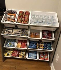 an assortment of snacks and drinks are stacked on top of each other in bins