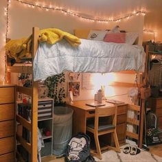 a bedroom with a bunk bed, desk and chair next to a string of lights