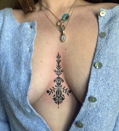 a woman's chest with an intricate tattoo design on her chest and the upper part of her breast