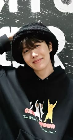 a young man wearing a black hoodie and hat