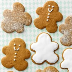 ginger cookies decorated with icing and sprinkles on a green and white checkered tablecloth