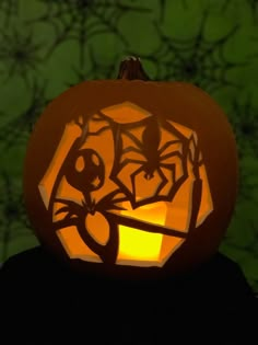 a carved pumpkin with an image of a cat on it's face in front of a green background