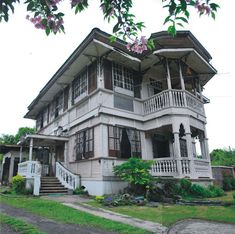 a large white house with lots of windows and balconies on the second floor