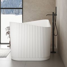 a white bath tub sitting in the middle of a bathroom next to a large window