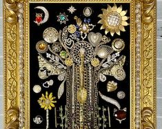 an ornate gold framed artwork with many different items in the center and on it's sides