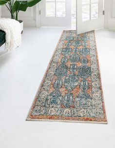 a large rug is on the floor in front of an open door with white walls